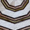 Close-up of Cannes Hide 28143 luxury designer rug with handmade hide hexagonal pattern in cream, brown, and olive green.