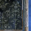 The Boulle Hide 29148 is a luxury designer rug with a dark floral motif and textured hide border on a blue floor.