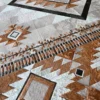 Luxury designer rug with brown, black, and gray geometric patterns in handmade hide.