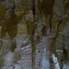 A close-up of luxury designer rugs showcases overlapping handmade hide pieces in rich brown and gray tones.
