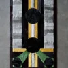 Luxury designer rug with geometric pattern, black circles, and colorful stripes on gray.