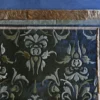 A close-up of the Boulle Hide 29148 luxury designer rug with ornate floral patterns, fur-like borders, and leather accents on a blue floor.