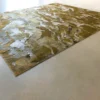 Submerge Hide 25491 high end designer rug with abstract gold and silver pattern, luxury handmade hide rug for upscale interiors.