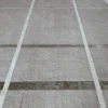 Close-up of a luxury custom rug with textured concrete look and precise white lines.