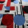 Luxury custom designer rug featuring red and blue circles on a high end handmade hide surface.