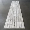 Luxury designer hide rug in white and light gray patchwork on a smooth gray floor.
