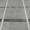 Concrete surface with parallel white lines resembles luxury custom handmade wool and silk designer rugs.