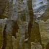 Close-up of Submerge Hide 25491, a luxury designer rug with handmade overlapping hides in brown and grey tones.