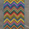 Luxury custom designer rug with bold chevron pattern on a gray concrete floor.