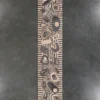 Long oval wooden sculpture with geometric patterns on gray, ideal for luxury designer rug inspiration.