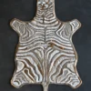 Luxury designer zebra hide rug 16332 with white and brown stripes on dark floor.