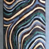 Drift Hide 29332 designer rug features wavy layered lines in luxe brown, green, cream, and blue on a muted handmade luxury rug.