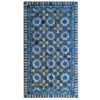This high end designer rug showcases a blue, beige, and brown geometric floral pattern with diamond and zigzag borders.