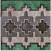 Luxury custom hide rug featuring green, gray, and beige geometric designer patterns.