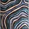 Luxury designer rug with wavy, layered blue and earth-tone stripes in a high-end modern pattern.