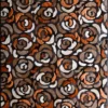 Close-up of luxury designer hide rug with swirling abstract floral patterns in brown, copper, white, and black.