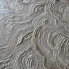 Close-up of Aubusson Hide 16290 luxury designer rug with textured beige tree ring patterns, showcasing high end handmade hide craftsmanship.