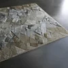 Luxury designer rug with abstract geometric pattern in neutral tones on gray floor.