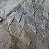 Close-up of a luxury designer rug with geometric gray and beige handmade hide rug pattern.