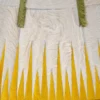 Close-up of luxury designer hide rug 26287 with white fur, yellow geometric motifs, and green fabric accents.
