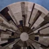 Luxury custom designer rug with geometric segments in brown, beige, and cream on blue.