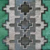 Luxury designer rectangular rug with green, gray, and beige geometric cross patterns and a plush handmade hide texture.