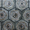 Close-up of a luxury designer rug with a geometric hexagonal pattern in metallic gray tones.