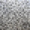 Close-up of a textured wall as a backdrop for luxury handmade designer rugs display.