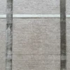 A beige wall with a grid evokes the fine texture of luxury handmade wool designer rugs.