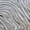Close-up of Drift Hide 28893 luxury handmade hide rug, wavy parallel stripes in beige, gray, and light brown for high end designer decor.