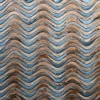 Close-up of luxury designer rug with wavy, zigzag patterns in blue and brown tones.