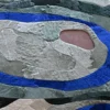 Luxury custom designer rug with layered blue, gray, and green shapes and a textured pink center.