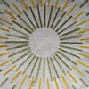 Elegant high end designer rug with gold and silver sunburst pattern on textured white.