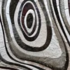 Concentric ovals in brown, black, gray, and white on a luxury custom designer hide rug.