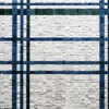 A luxury custom rug with intersecting blue and green grid lines on a white tiled design.