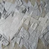 Close-up of designer luxury hide rug with abstract geometric patchwork in gray and beige.