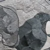 Luxury designer rug with overlapping gray and white shapes, fur-like texture, and dark outlines.