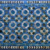 Luxury designer hide rug with geometric blue, green, and beige octagon patterns and a decorative border.