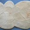 Luxury designer beige custom hide rug with abstract ovals on a blue floor.