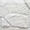 Close-up of Lexar Hide 15275, a luxury designer hide rug with geometric white patches.