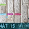 Luxury custom designer rug made from multicolored fur panels with "WHAT IS A MAN" cut out on teal hide.