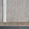 Luxury designer rug with beige wool base, silk accents, and refined border on a gray floor.