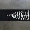 Luxury designer wool rug in black with white fish skeleton motif, on concrete floor.