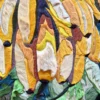 Close-up of a luxury designer hide rug, featuring abstract layered leaf forms and stitched textures in rich colors.