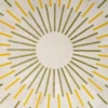 Radiating yellow and green lines form a circular pattern on beige luxury designer rug.