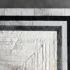 Faceta Hide 15388 luxury designer rug, rectangular with concentric bands of white, gray, and black fur-like textures on a smooth gray floor.