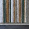 Close-up of Jet Stream Wool 15357 high end designer rug in green, beige, gray, and brown on a dark floor.