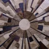 Luxury designer rug with abstract sunburst pattern and textured, handmade hide segments.