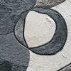 Close-up of a luxury designer rug with an abstract pattern in gray, black, and white faux fur.
