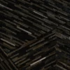 Close-up of a luxury designer rug’s textured hide surface with stacked geometric strips.
